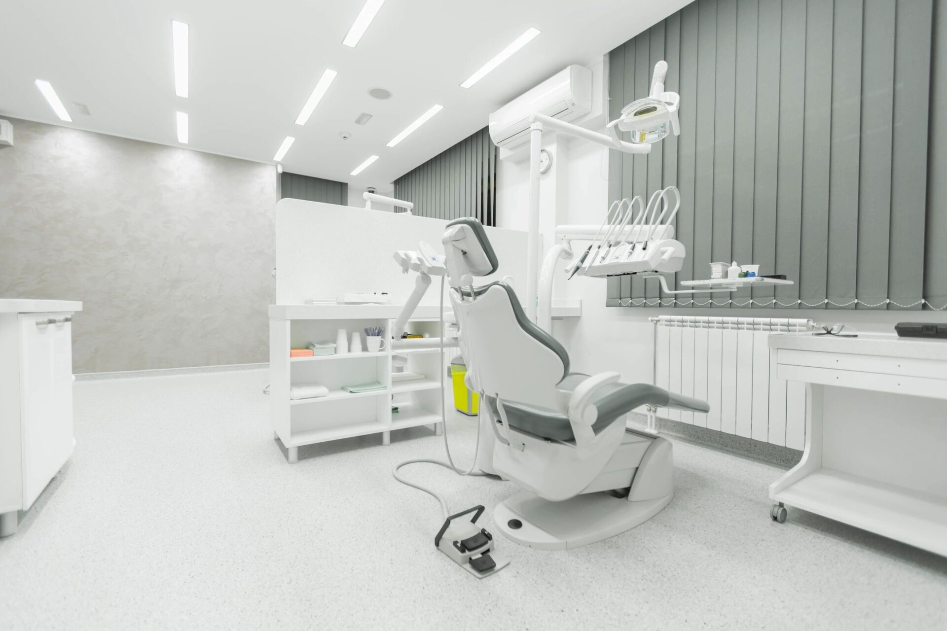 Interior design of dentist surgery room in medical clinic with chair and equipment A dentist 's office with a chair and equipment.
